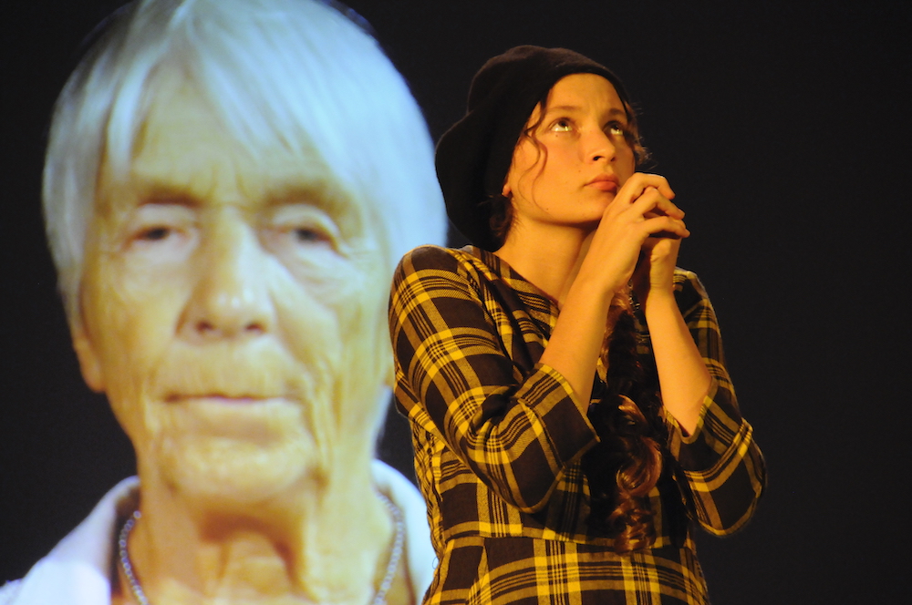 Mädchen betet, im Hintergrund alte Frau