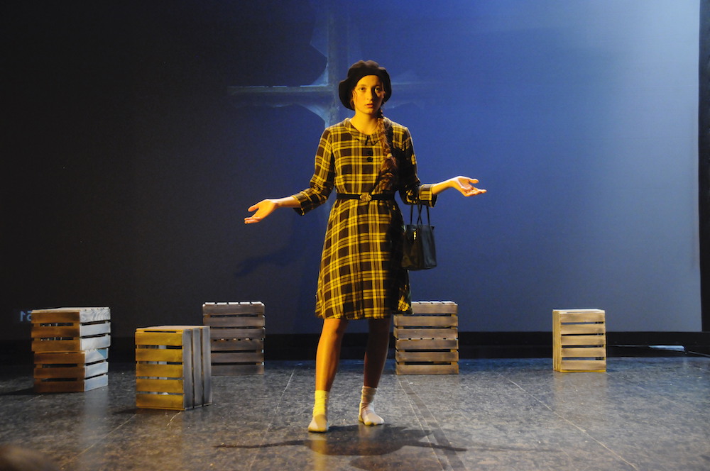 Mädchen im Karokleid, Hände seitlich ausgebreitet, ratlos